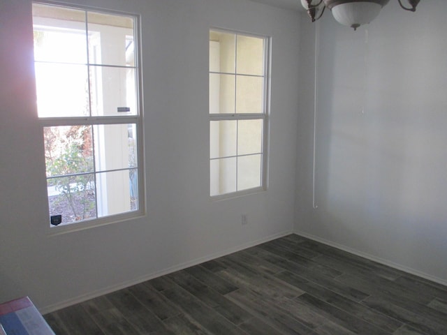 spare room with dark wood-style floors and baseboards