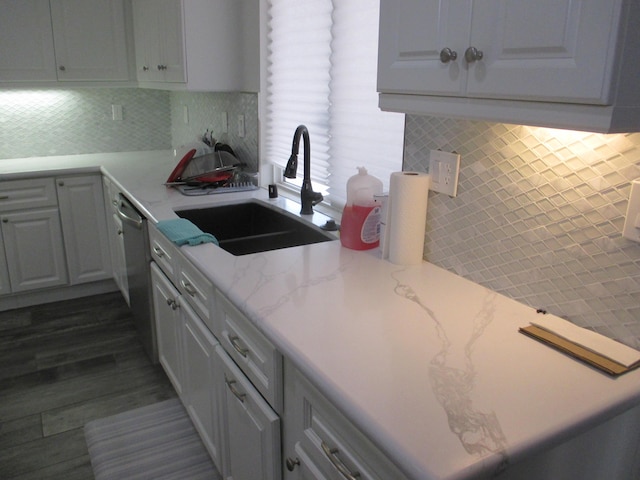 kitchen featuring a sink, backsplash, and light stone countertops