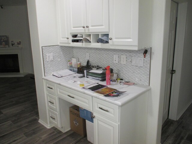 kitchen with tasteful backsplash, white cabinets, dark wood-type flooring, and light countertops