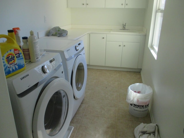 clothes washing area with cabinet space, washer and clothes dryer, and a sink