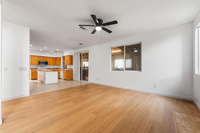 unfurnished living room featuring ceiling fan and light hardwood / wood-style floors