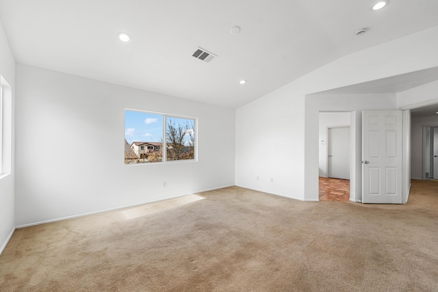 carpeted spare room featuring lofted ceiling