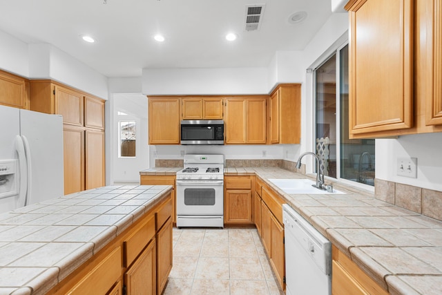 kitchen featuring tile counters, light tile patterned flooring, white appliances, and sink