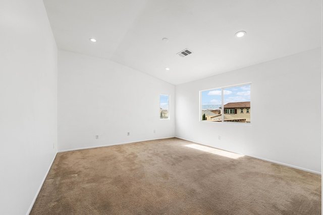 unfurnished room featuring carpet flooring and lofted ceiling