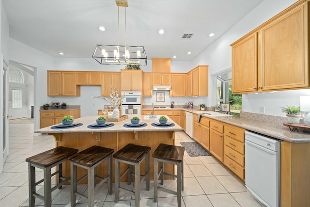 kitchen with white appliances, light tile patterned flooring, recessed lighting, and a sink