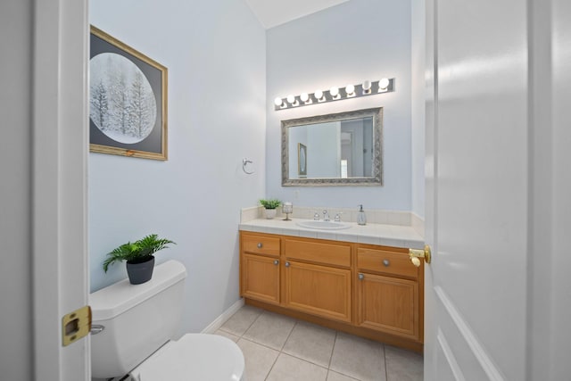 bathroom with toilet, vanity, and tile patterned flooring