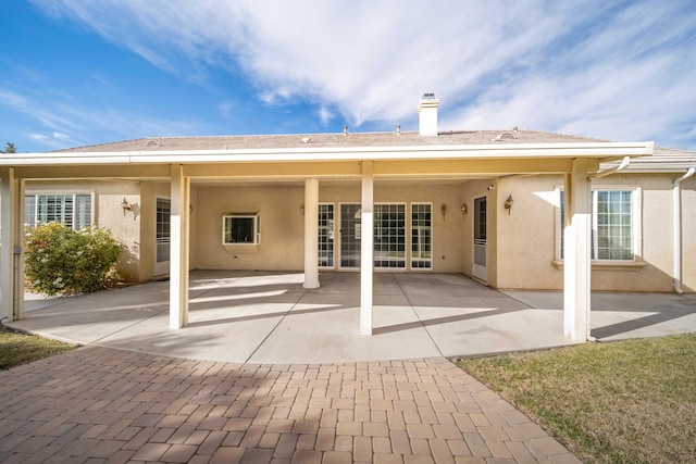 back of house featuring stucco siding and a patio area