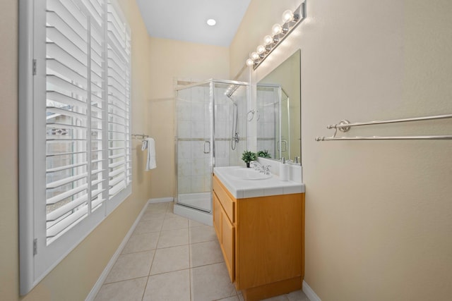 full bathroom with baseboards, a stall shower, vanity, and tile patterned flooring