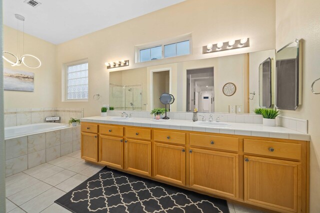 bathroom featuring a sink, a bath, a shower stall, and tile patterned floors