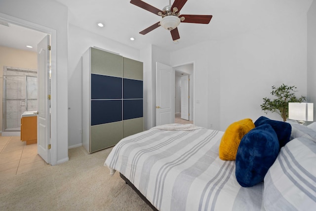 bedroom featuring ceiling fan, light colored carpet, light tile patterned floors, recessed lighting, and ensuite bathroom