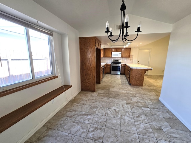 kitchen featuring tasteful backsplash, vaulted ceiling, hanging light fixtures, kitchen peninsula, and stainless steel stove