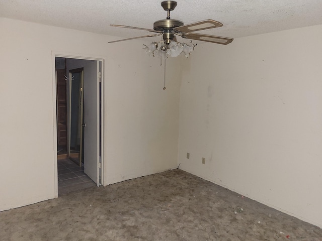 empty room with ceiling fan and a textured ceiling