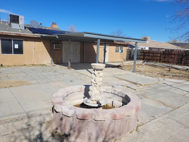 rear view of property featuring central air condition unit, a patio area, and an AC wall unit