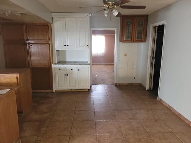 kitchen featuring light tile patterned flooring, ceiling fan, and a textured ceiling