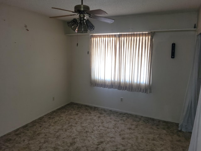 unfurnished room featuring ceiling fan, carpet, and a textured ceiling