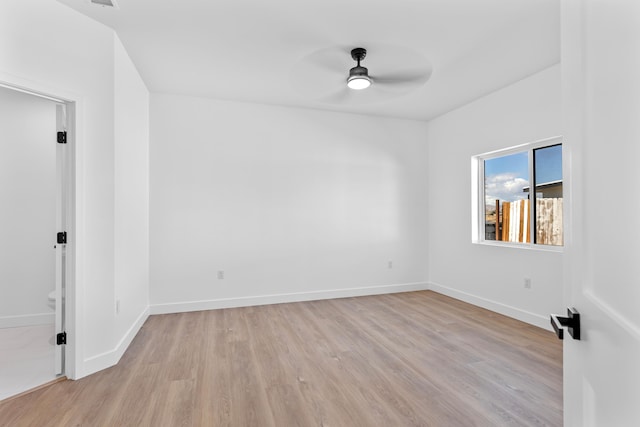 unfurnished room featuring baseboards, light wood-type flooring, and ceiling fan