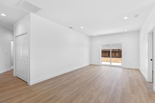 spare room featuring baseboards, visible vents, attic access, recessed lighting, and light wood-type flooring