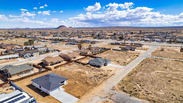 aerial view featuring view of desert, a mountain view, and a residential view