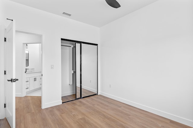 unfurnished bedroom with a ceiling fan, visible vents, baseboards, light wood-style floors, and a closet