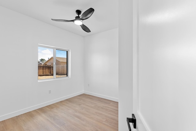 empty room featuring baseboards, a ceiling fan, and light wood finished floors