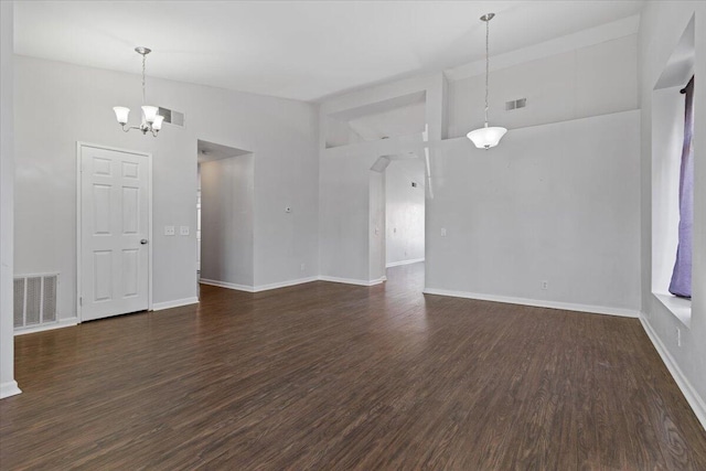 spare room with dark hardwood / wood-style floors, a chandelier, and high vaulted ceiling