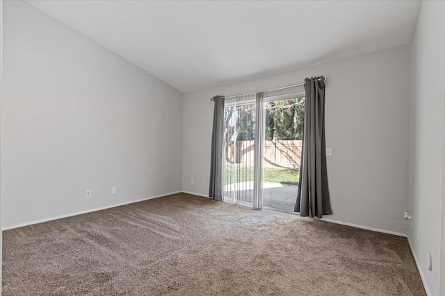 carpeted empty room with lofted ceiling