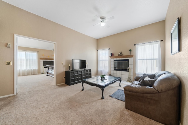 carpeted living room featuring a fireplace and ceiling fan