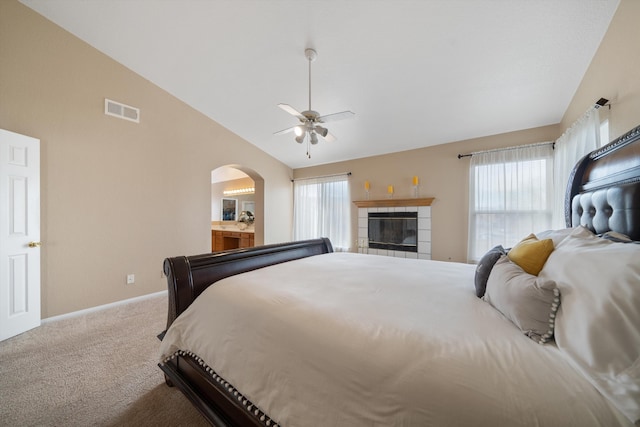 bedroom featuring carpet flooring, ceiling fan, a fireplace, and vaulted ceiling