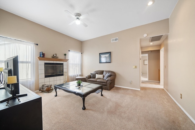 living room with ceiling fan, a fireplace, and light carpet