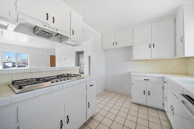 kitchen featuring white cabinetry, backsplash, stainless steel gas cooktop, tile countertops, and light tile patterned floors