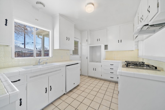 kitchen featuring white cabinets, dishwasher, stainless steel gas stovetop, and tile countertops