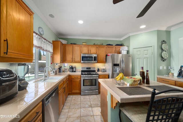 43432 Bale Ct, Lancaster, CA 93535 - kitchen with appliances with stainless steel finishes, tile countertops, ceiling fan, crown molding, and brown cabinets