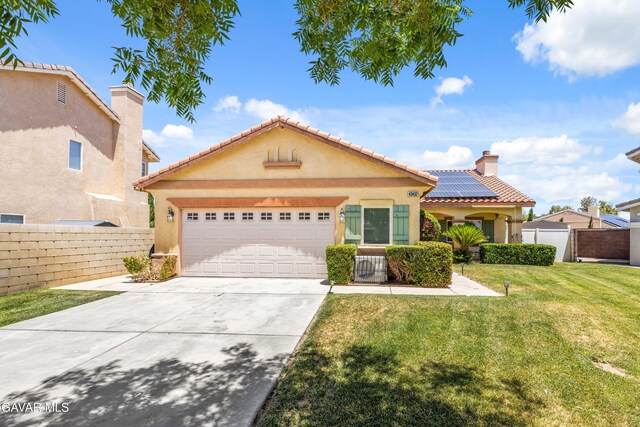 43432 Bale Ct, Lancaster, CA 93535 - view of front of house featuring roof mounted solar panels, a garage, concrete driveway, stucco siding, and a tile roof