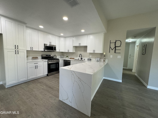 25561 Alicante Dr, Santa Clarita, CA 91355 - kitchen featuring appliances with stainless steel finishes, a peninsula, white cabinetry, recessed lighting, and wood finished floors