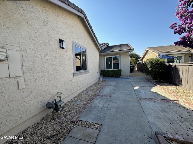 25561 Alicante Dr, Santa Clarita, CA 91355 - view of side of home featuring stucco siding, a fenced backyard, and a patio area