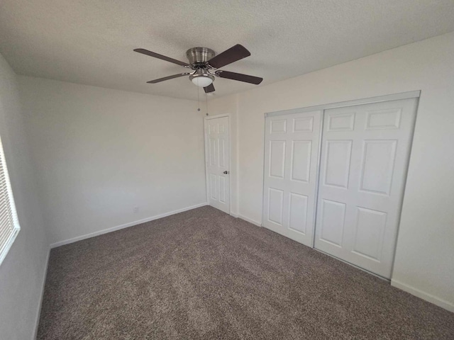 unfurnished bedroom with carpet flooring, a closet, a textured ceiling, baseboards, and a ceiling fan
