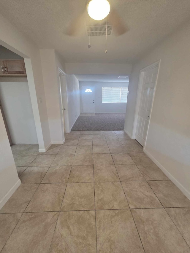 hallway featuring light tile patterned floors and baseboards