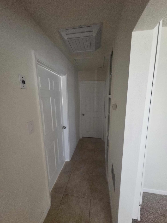 corridor with tile patterned floors and baseboards