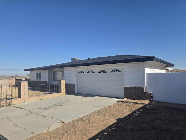 view of front of house with an attached garage, fence, and driveway