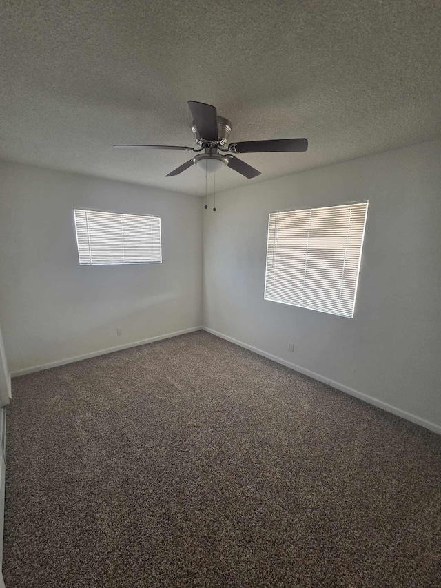 carpeted empty room with a textured ceiling, baseboards, and a ceiling fan