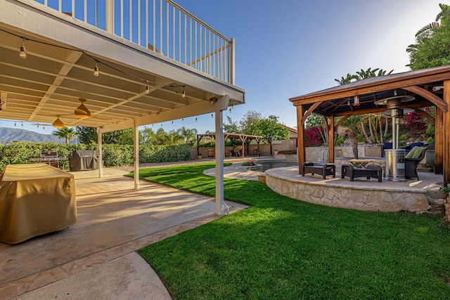 28367 Mount Stephen Ave, Santa Clarita, CA 91387 - view of green lawn with a gazebo, a fire pit, a patio, and ceiling fan