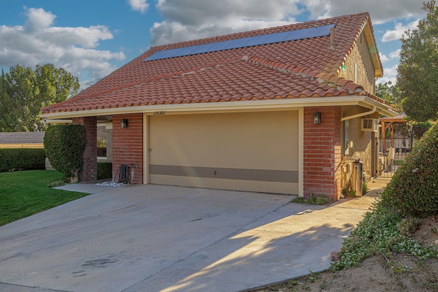 28367 Mount Stephen Ave, Santa Clarita, CA 91387 - view of front of house with concrete driveway, brick siding, a tile roof, an attached garage, and roof mounted solar panels