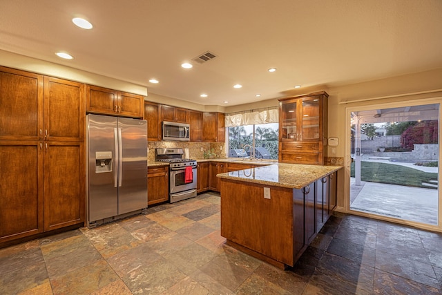 28367 Mount Stephen Ave, Santa Clarita, CA 91387 - kitchen with appliances with stainless steel finishes, a peninsula, stone tile floors, recessed lighting, and tasteful backsplash