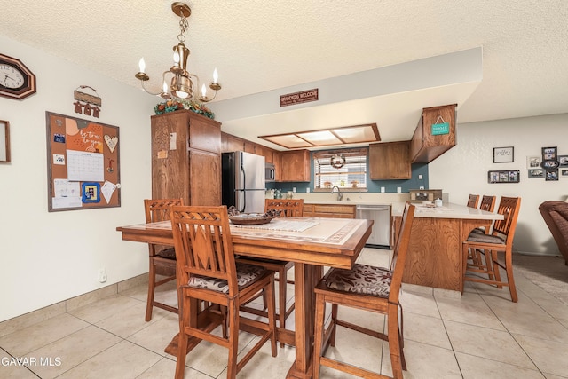 1037 Herzel Ave, Lancaster, CA 93535 - dining area with a chandelier, light tile patterned flooring, and a textured ceiling