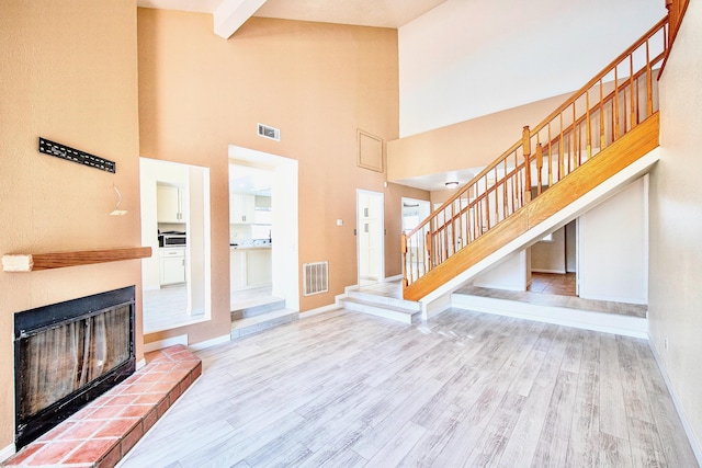 42443 Surrey Ct, Quartz Hill, CA 93536 - entrance foyer with stairway, a high ceiling, wood finished floors, baseboards, and a glass covered fireplace