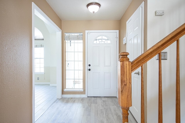 42443 Surrey Ct, Quartz Hill, CA 93536 - entryway with light wood-type flooring, arched walkways, baseboards, and stairs