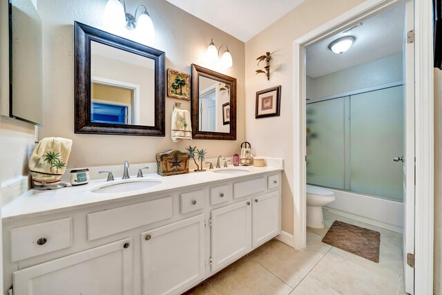 39884 Golfers Dr, Palmdale, CA 93551 - full bathroom featuring toilet, double vanity, tile patterned floors, and bath / shower combo with glass door