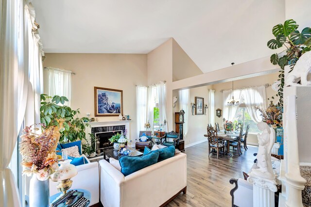 39884 Golfers Dr, Palmdale, CA 93551 - living area with wood finished floors, a high end fireplace, a chandelier, high vaulted ceiling, and baseboards
