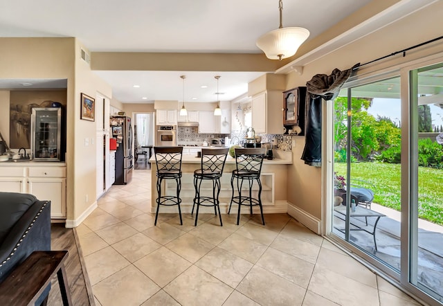 39884 Golfers Dr, Palmdale, CA 93551 - kitchen featuring appliances with stainless steel finishes, tasteful backsplash, a peninsula, white cabinets, and pendant lighting