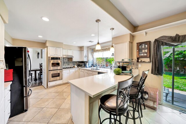 39884 Golfers Dr, Palmdale, CA 93551 - kitchen with stainless steel appliances, a peninsula, a sink, white cabinetry, and recessed lighting